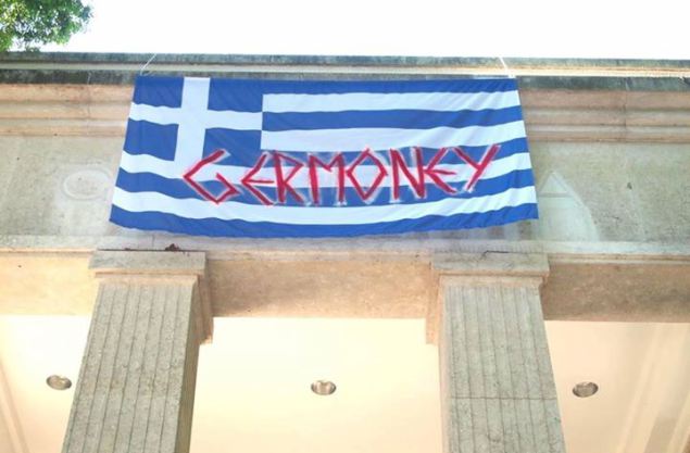 图14 2015年7月德国馆前挂上了希腊国旗，并写上“德国的钱”。在希腊债务危机解决后，德国馆还把此次事件作成复印件，任后来的观众自取